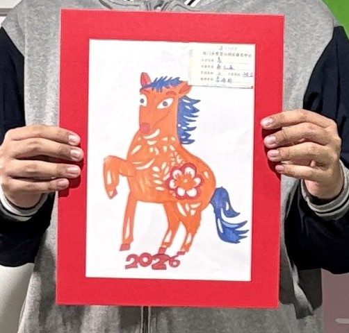 Hands holding up the original painting of the 2026 horse that is printed on the box lid
