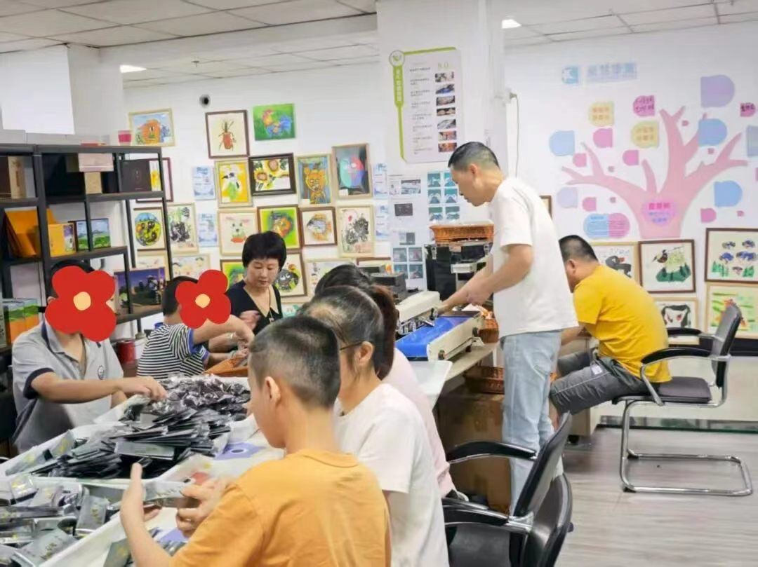 Aihui members packing pouches of tea side by side at the tea studio in Xiamen, Fujian
