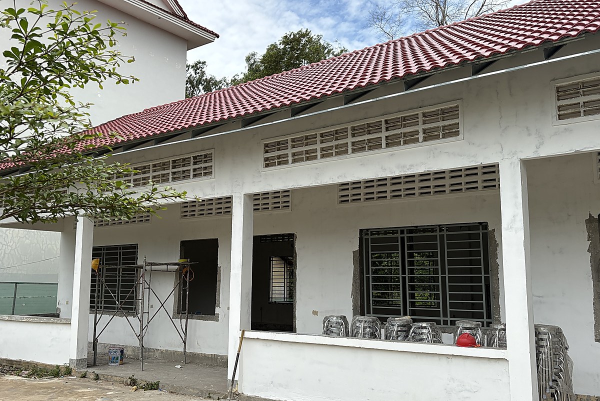 The 2006 school block under refurbishment, with a new tiled roof, new window frames and stacked chairs on the veranda