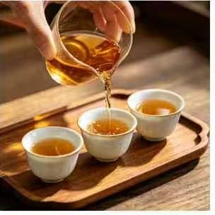 Tea being shared evenly from the pitcher into small cups