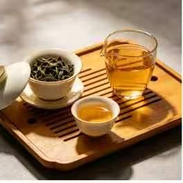 A gaiwan, a fairness pitcher and small cups laid out on a tea tray